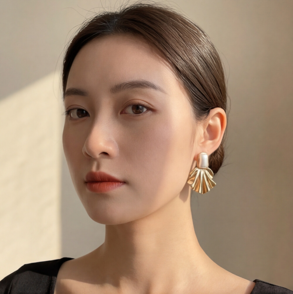 Brinco Dourado com detalhe perolado e design de concha