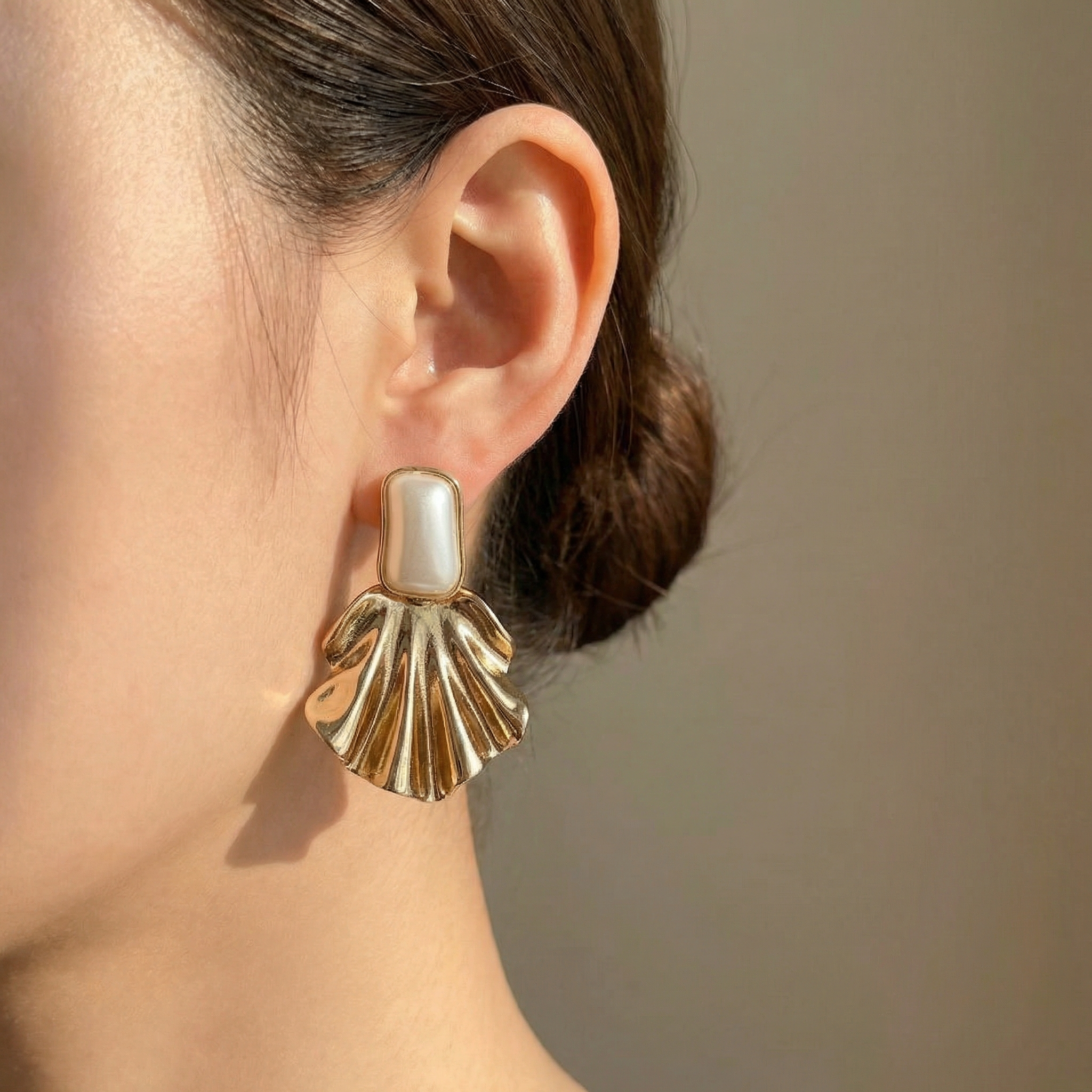 Brinco Dourado com detalhe perolado e design de concha